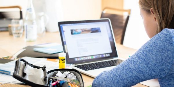 Estudiante hace tareas delante de su ordenador